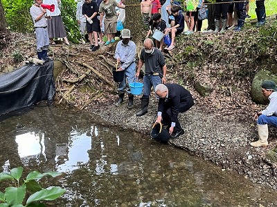 ヤマメを放流する市長の写真