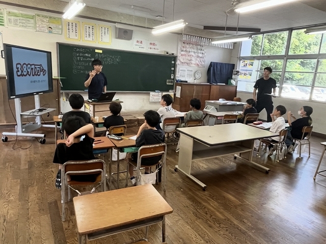 教室で説明を聞く児童の様子