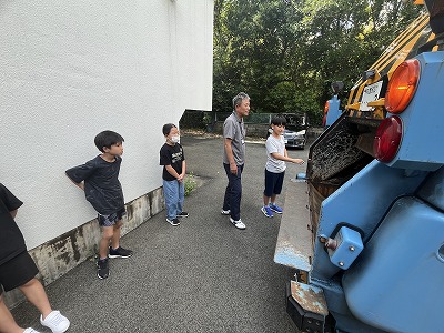 順番に収集車に触る児童の様子