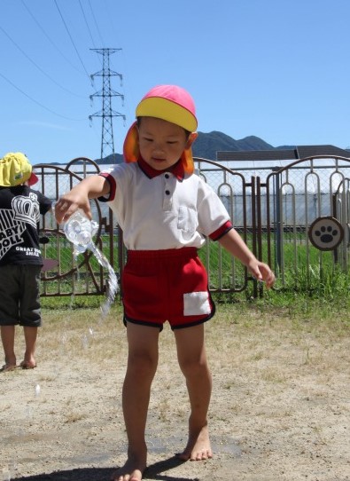 打ち水をする園児