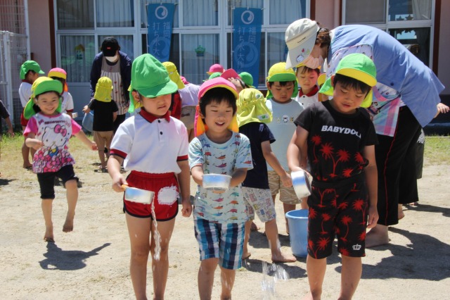 打ち水をする園児たち