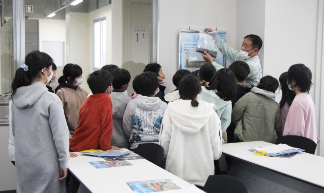 職員の話を真剣に聞く、児童たち