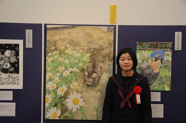 のおがた子どもアート大賞受賞の絵と作者の写真。絵は猫とノースボール