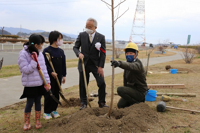市長と子どもが植樹用の桜の木の前で話している写真