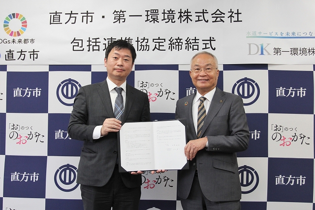 協定書を手にした玉木社長（左）と大塚市長