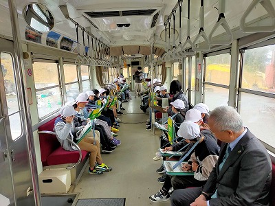 汽車俱楽部で児童と一緒に説明を受ける市長の写真