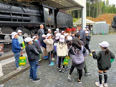 汽車倶楽部で児童と一緒に話を聴く市長の写真