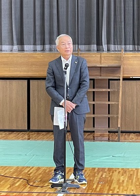 市長が体育館のステージ前で参加者に話をしている写真