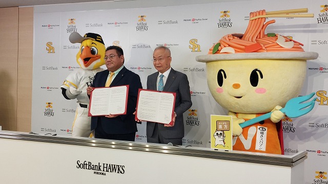 協定書を手にする福岡ソフトバンクホークスの本田専務（左）と大塚市長