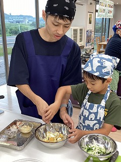 サラダの材料を混ぜる子どもさん