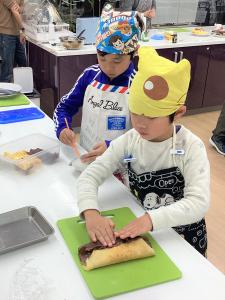 プレーンとココアの生地を重ねてオリジナルのクレープケーキをつくる男の子